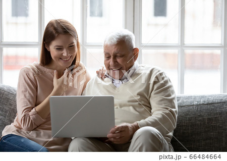 Happy older father and grownup daughter looking at laptop screen 66484664