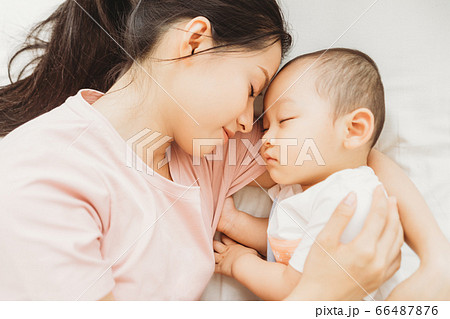 Mother and son sleeping on bed 66487876