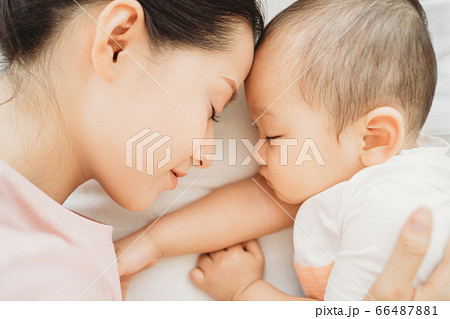 Mother and son sleeping on bed 66487881