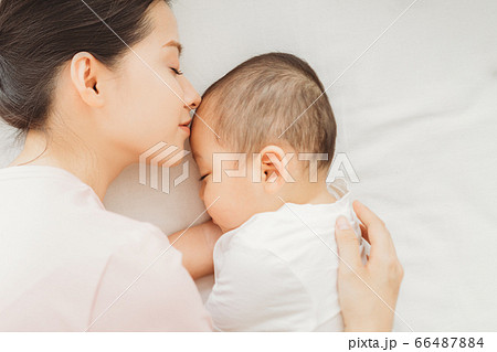 Mother and son sleeping on bed 66487884