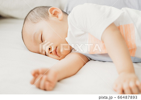 A child sleeping on bed 66487893