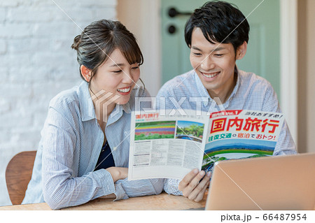 旅行のパンフレットを見ながら計画を立てる男女 旅行のパンフレットを見ながら計画を立てる男女 66487954