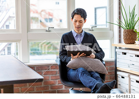リラックスして自宅でタブレットを見る男性 66488131