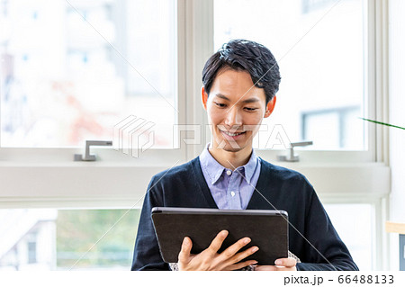 リラックスして自宅でタブレットを見る男性 リラックスして自宅でタブレットを見る男性 66488133
