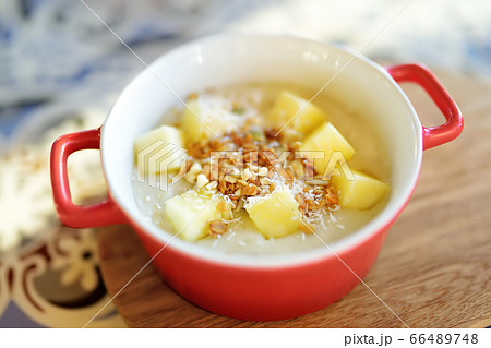 Pudding with fruits, nuts and seeds in red bowl  66489748