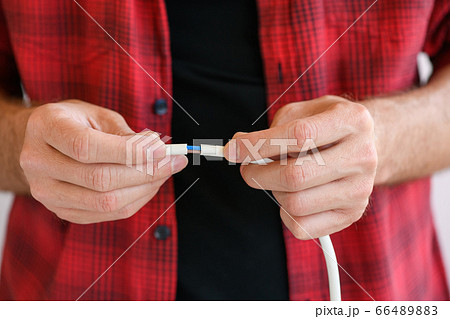 Male hands connect electric wires close up 66489883