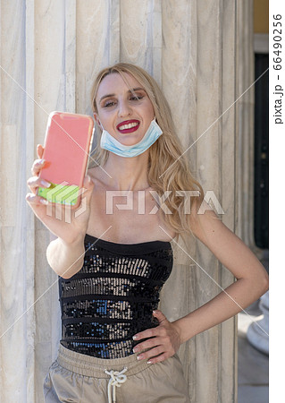 beautiful blond girl smiling with face mask after lock down reopening 66490256