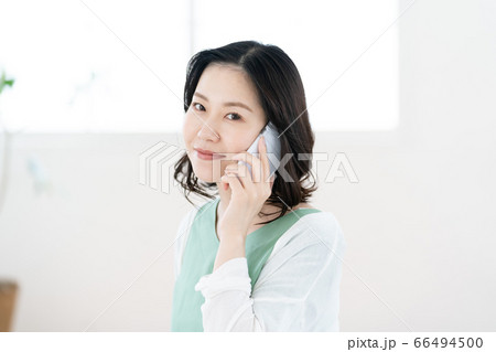 スマホで通話するミドル女性【リビング】 スマホで通話するミドル女性【リビング】 66494500