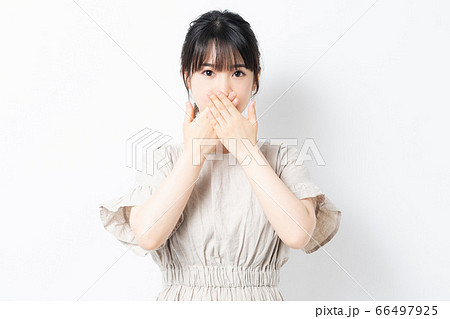 口に手を当てる若い女性の写真素材