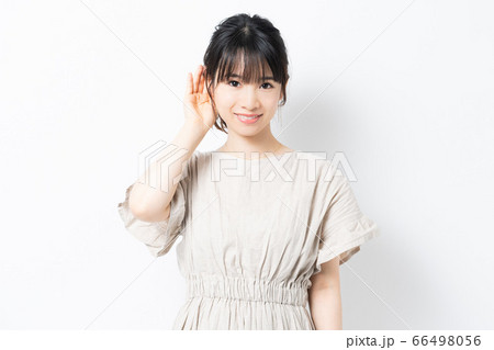 聞き耳をたてる若い女性 聞き耳をたてる若い女性 66498056