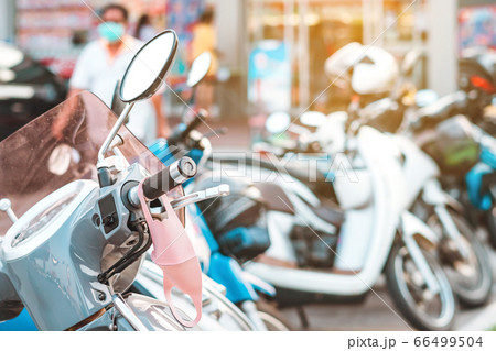 A mask hanging on a motorcycle handle to prevent germs (Covid-19) on roadside in the city. Corona virus protection concept. 66499504