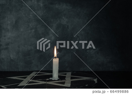 Close up one burning candles and the Star of David 66499886