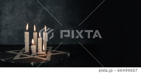 Six burning candles and the Star of David against Six burning candles and the Star of David against 66499887