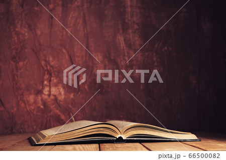 Beautiful ancient open old book on a red wooden Beautiful ancient open old book on a red wooden 66500082