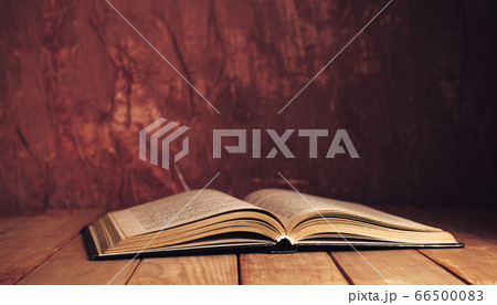 Beautiful ancient open old book on a red wooden Beautiful ancient open old book on a red wooden 66500083