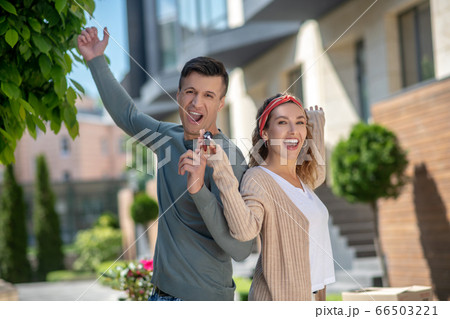 Happy young couple feeling great after getting the key from their new house Happy young couple feeling great after getting the key from their new house 66503221
