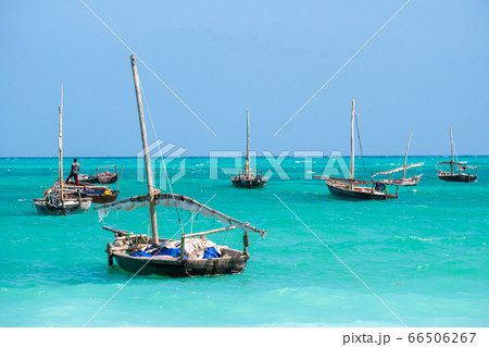 Anchored Traditional wooden dhow boats on the amazing turquoise water in the Indian ocean at Nungwi village, Zanzibar, Tanzania Anchored Traditional wooden dhow boats on the amazing turquoise water in the Indian ocean at Nungwi village, Zanzibar, Tanzania 66506267