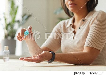 Mixed-Race Woman Sanitizing Hands 66507607