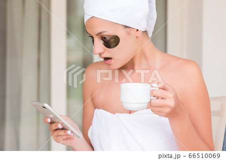 Wrapped in towel after shower woman with eye 66510069