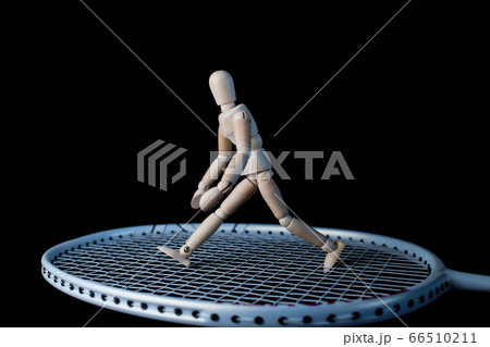 バドミントンのラケットの上にある可愛いデッサン人形の写真素材