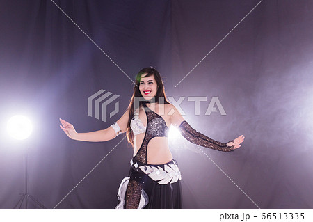 Belly dancer. Young attractive woman dancing tribal fusion on the stage. Oriental exotic dance. Belly dancer. Young attractive woman dancing tribal fusion on the stage. Oriental exotic dance. 66513335