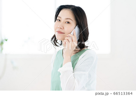 スマホで通話するミドル女性【リビング】 スマホで通話するミドル女性【リビング】 66513364