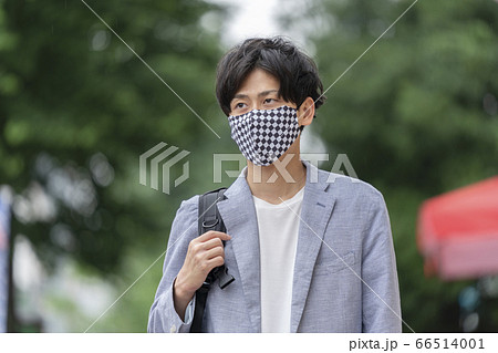 チェッカー柄のマスクを着用した若い男性 66514001