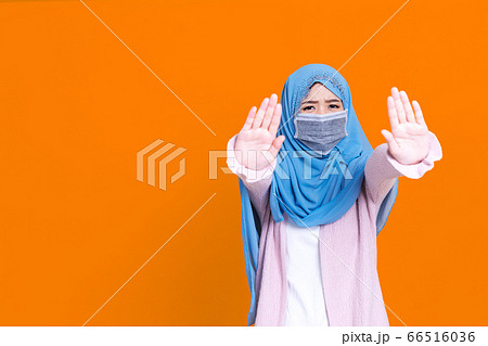 Asian serious muslim woman wears hijab, makes Asian serious muslim woman wears hijab, makes 66516036