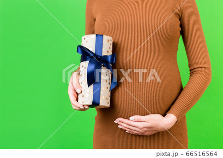 Cropped image of pregnant woman in brown dress Cropped image of pregnant woman in brown dress 66516564