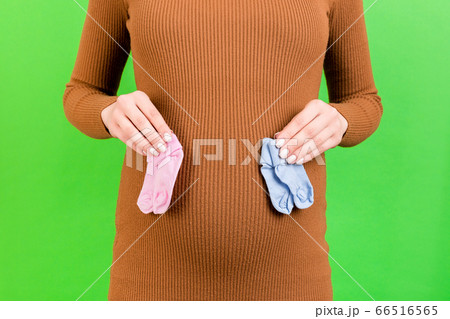 Cropped portrait of pregnant woman in brown dress Cropped portrait of pregnant woman in brown dress 66516565