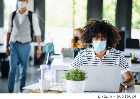 Portrait of young man with face mask back at work in office after lockdown. 66516624