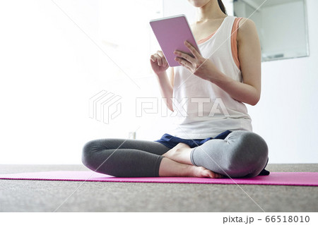 部屋の中でヨガを行う若い日本人女性 66518010