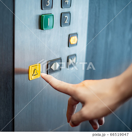 Male hand pressing on emergency button in elevator 66519047