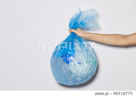 Woman holding garbage bag 66519775