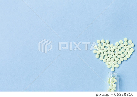 Group of yellow round tablets forms a heart shape Group of yellow round tablets forms a heart shape 66520816