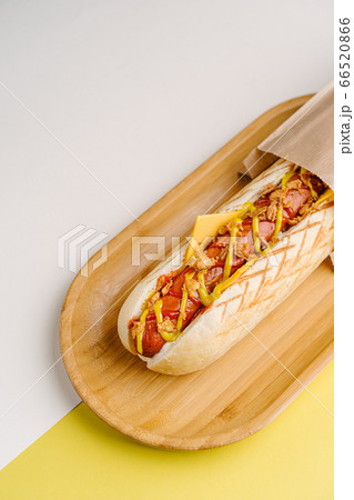 Grilled Hot Dog with cheese on wooden plate Grilled Hot Dog with cheese on wooden plate 66520866