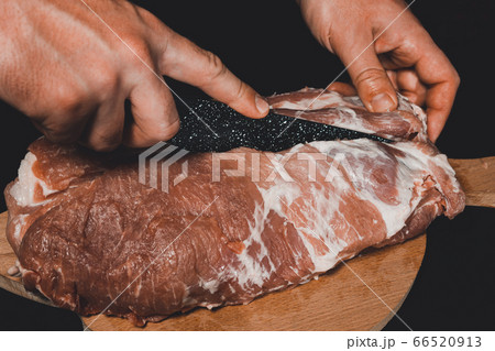 The chef of the restaurant in a dark uniform cuts The chef of the restaurant in a dark uniform cuts 66520913