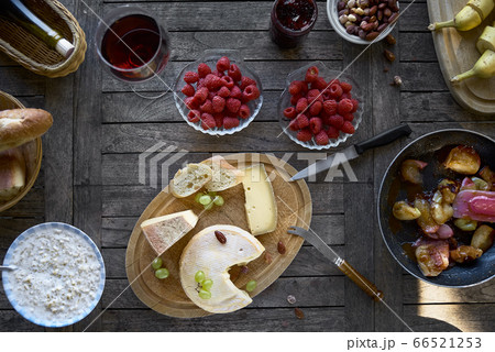 Assortment of cheese on a wooden tray with wine Assortment of cheese on a wooden tray with wine 66521253