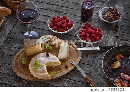 Assortment of cheese on a wooden tray with wine Assortment of cheese on a wooden tray with wine 66521254