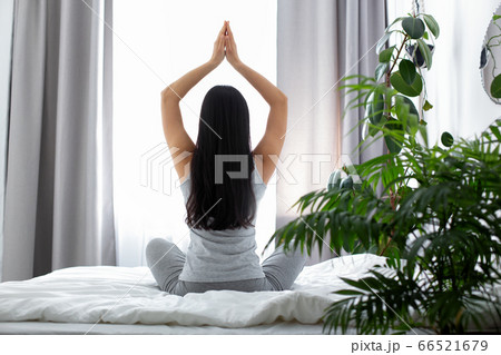 Slim woman doing yoga in bedroom in morning Slim woman doing yoga in bedroom in morning 66521679