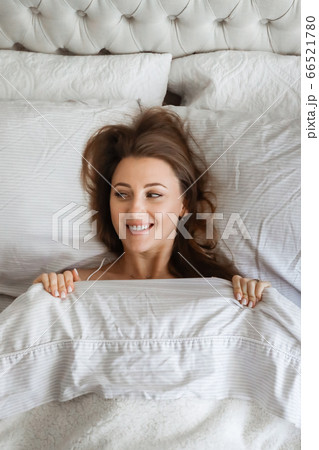Happy young woomen in the bed. Girl spending time at home. Home vacation. Morning concept Happy young woomen in the bed. Girl spending time at home. Home vacation. Morning concept 66521780