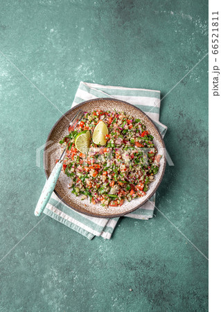 Traditional Lebanese salad tabouli tabule with quinoa, herbs, tomatoes, mint and lemon 66521811
