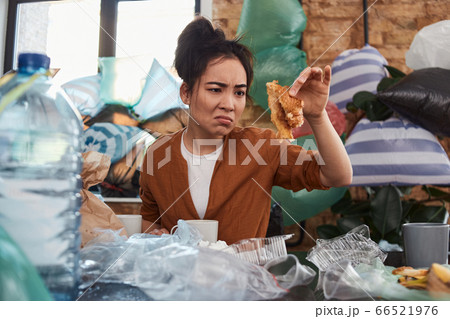 Untidy woman looking painfully on the last scrap of prepared food Untidy woman looking painfully on the last scrap of prepared food 66521976