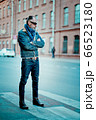 a man walks in the street, he has denim jacket, glasses, mustache and beard a man walks in the street, he has denim jacket, glasses, mustache and beard 66523180
