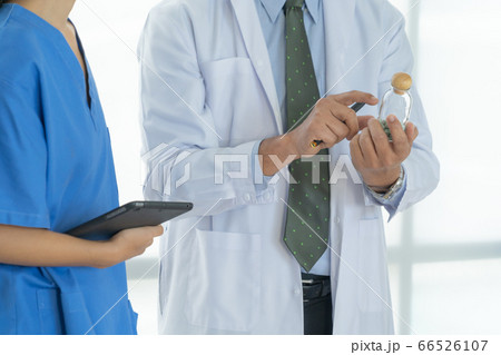 Doctor hand holding a medicine bottle for test in Doctor hand holding a medicine bottle for test in 66526107
