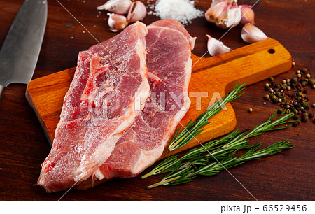Preparation of raw pork shoulder on wooden board 66529456