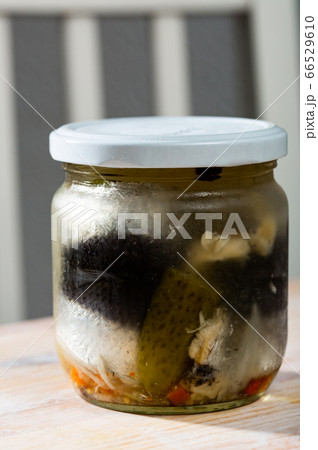 Marinated herring with onions in a glass jar 66529610