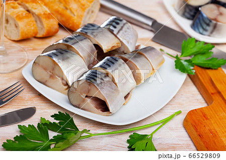 Slices of lightly salted mackerel with greens at plate 66529809