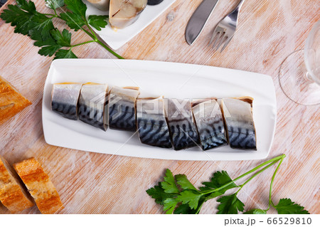 Lightly salted mackerel cut into pieces with parsley on table 66529810