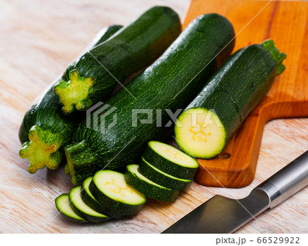Whole and sliced fresh zucchini on wooden table Whole and sliced fresh zucchini on wooden table 66529922